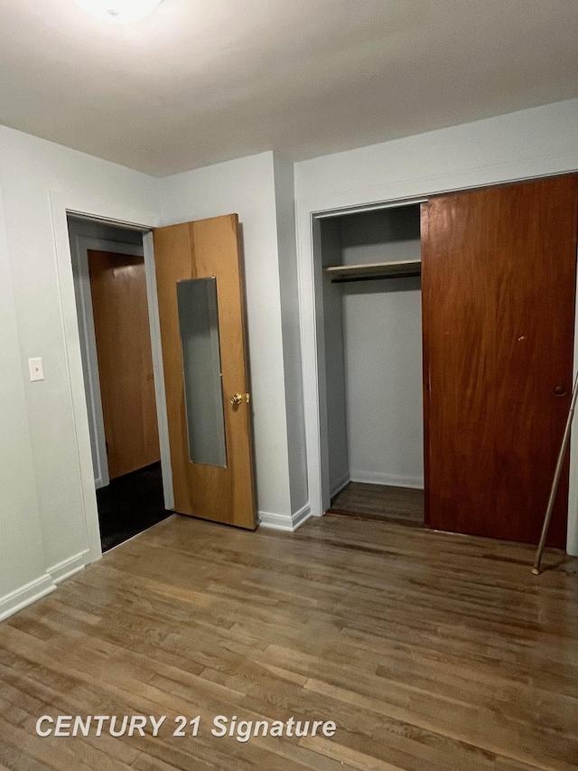 2222 Stone St, Saginaw, MI 48602 - unfurnished bedroom with wood finished floors, a closet, and baseboards