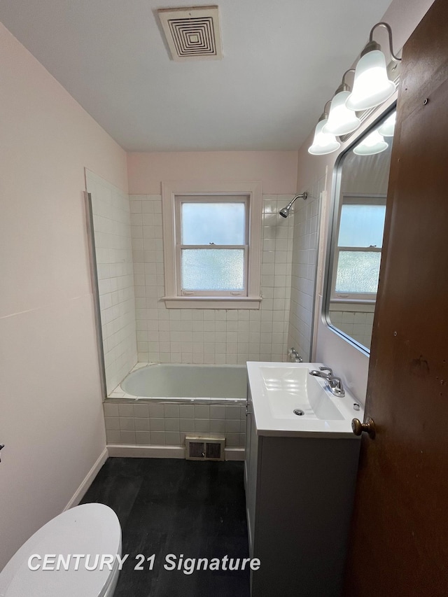 2222 Stone St, Saginaw, MI 48602 - bathroom with toilet, vanity, tiled shower / bath combo, and baseboards
