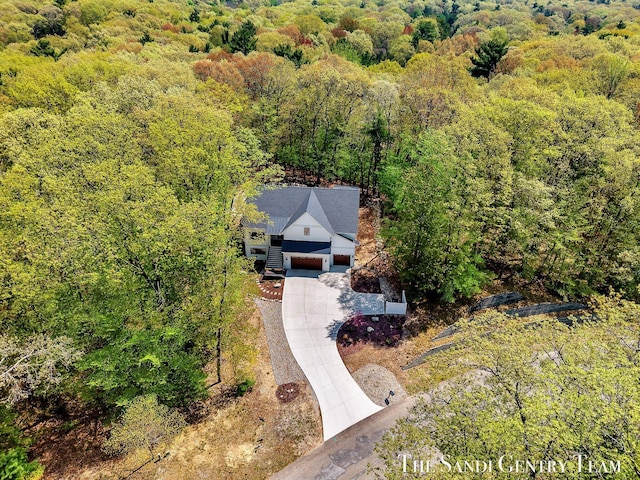 aerial view of property and surrounding area featuring a forest