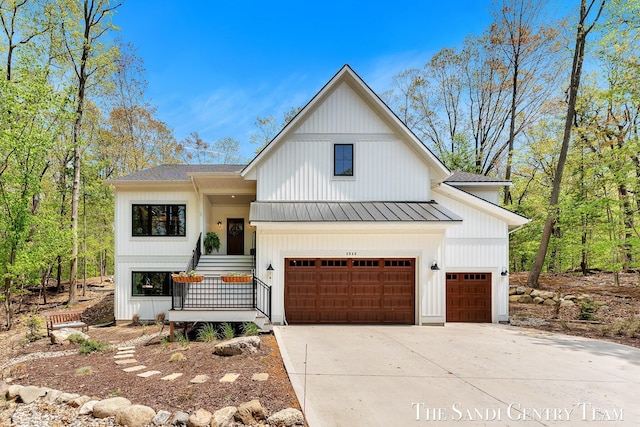 modern farmhouse featuring a standing seam roof, concrete driveway, metal roof, and a garage