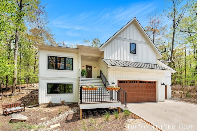 modern inspired farmhouse featuring driveway, a standing seam roof, an attached garage, metal roof, and board and batten siding