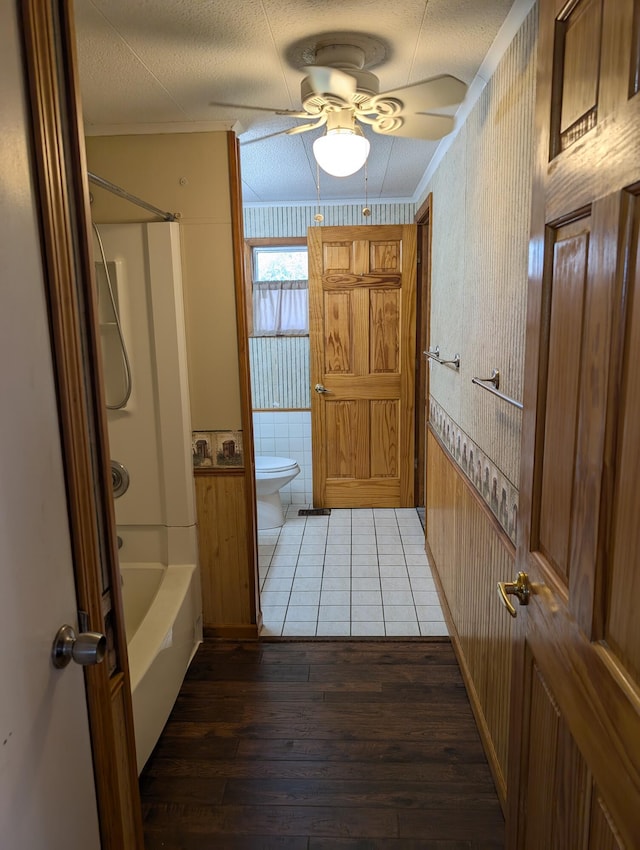 602 Fourth St, Ludington, MI 49431 - full bathroom with wood-type flooring, a ceiling fan, toilet, bathing tub / shower combination, and crown molding