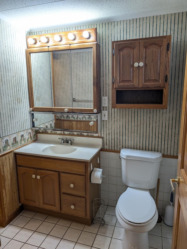 602 Fourth St, Ludington, MI 49431 - half bathroom with wallpapered walls, toilet, tile patterned flooring, vanity, and a textured ceiling