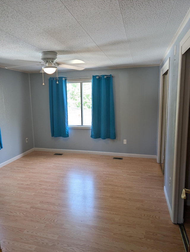 602 Fourth St, Ludington, MI 49431 - unfurnished room featuring light wood-style floors, a ceiling fan, baseboards, and a textured ceiling