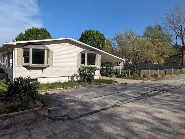 602 Fourth St, Ludington, MI 49431 - view of home's exterior with fence and a carport