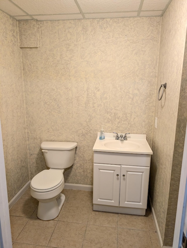 602 Fourth St, Ludington, MI 49431 - half bath featuring toilet, vanity, baseboards, tile patterned flooring, and wallpapered walls