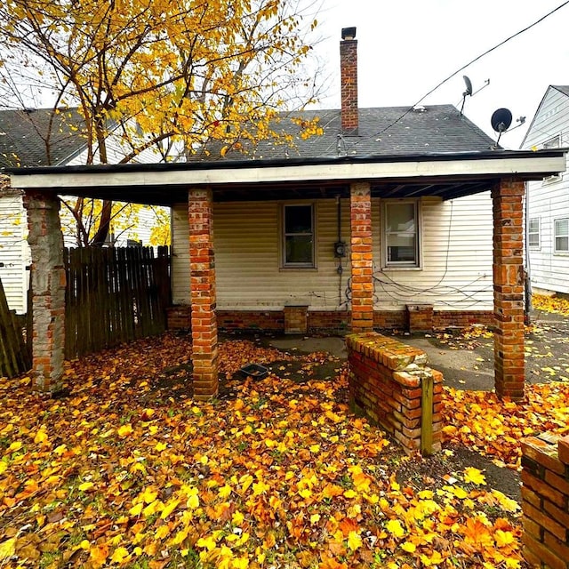 19731 Harlow St, Detroit, MI 48235 - rear view of property featuring a chimney, fence, and a porch