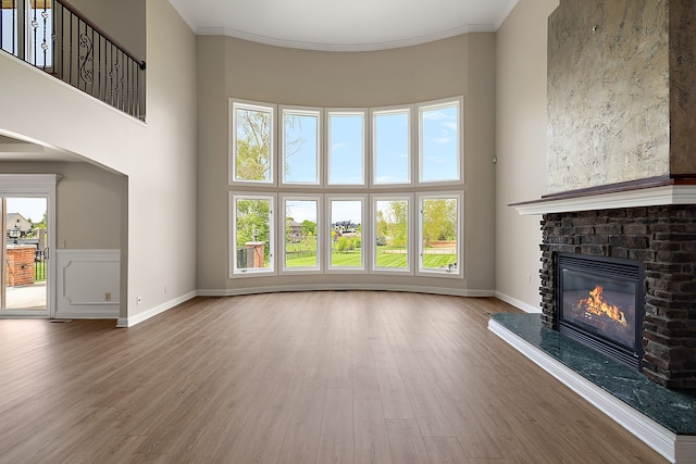 66701 Notre Dame Blvd, Washington, MI 48095 - unfurnished living room featuring a glass covered fireplace, wood finished floors, a high ceiling, and ornamental molding