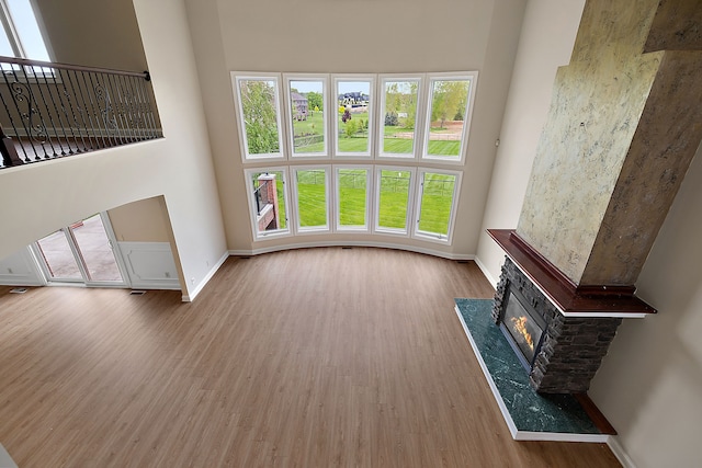 66701 Notre Dame Blvd, Washington, MI 48095 - unfurnished living room featuring wood finished floors, a high end fireplace, and a high ceiling