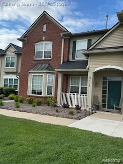4412 Aster Blvd, Howell, MI 48843 - view of front of property featuring covered porch, a front lawn, and brick siding