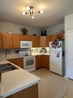 4412 Aster Blvd, Howell, MI 48843 - kitchen featuring white appliances, a sink, brown cabinets, and light countertops