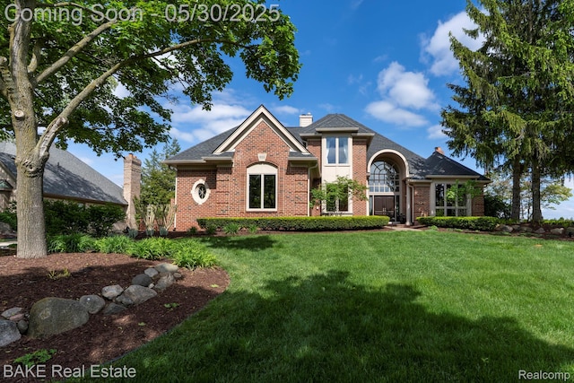 966 Mcdonald Dr, Northville, MI 48167 - traditional-style house featuring brick siding, a front yard, and a chimney