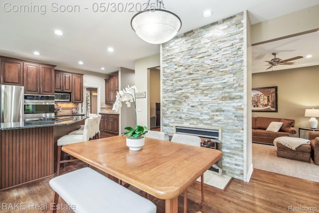 966 Mcdonald Dr, Northville, MI 48167 - dining area with light wood-style flooring, ceiling fan, recessed lighting, and a stone fireplace