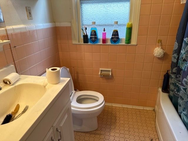 17659 Teppert St, Detroit, MI 48234 - full bath with tile walls, toilet, vanity, tile patterned floors, and shower / tub combo