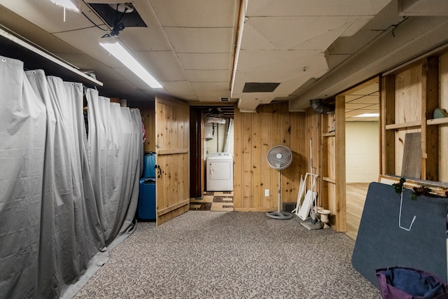 finished basement featuring washer / dryer, carpet, and wood walls