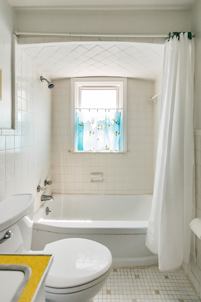 bathroom featuring toilet, shower / bath combination with curtain, and tile patterned flooring