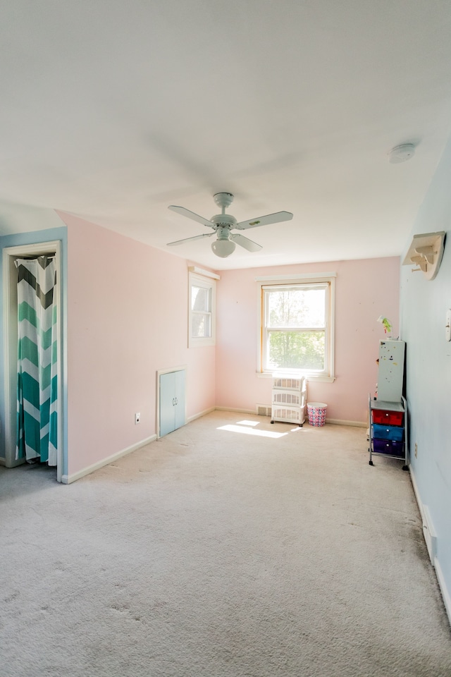 spare room featuring ceiling fan, carpet flooring, baseboards, and a smoke detector