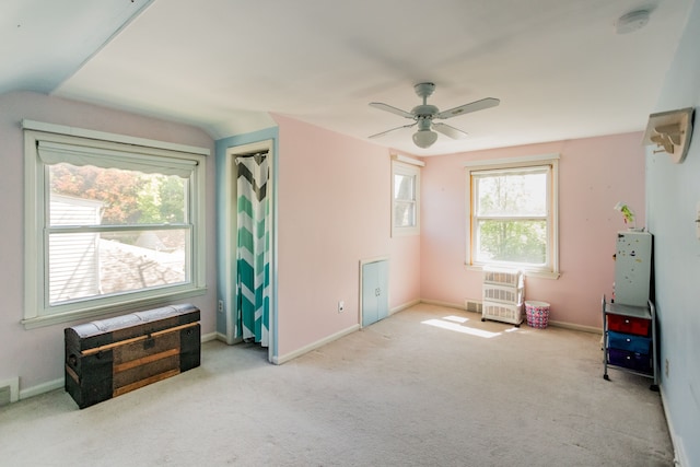 interior space with a smoke detector, a ceiling fan, baseboards, vaulted ceiling, and heating unit