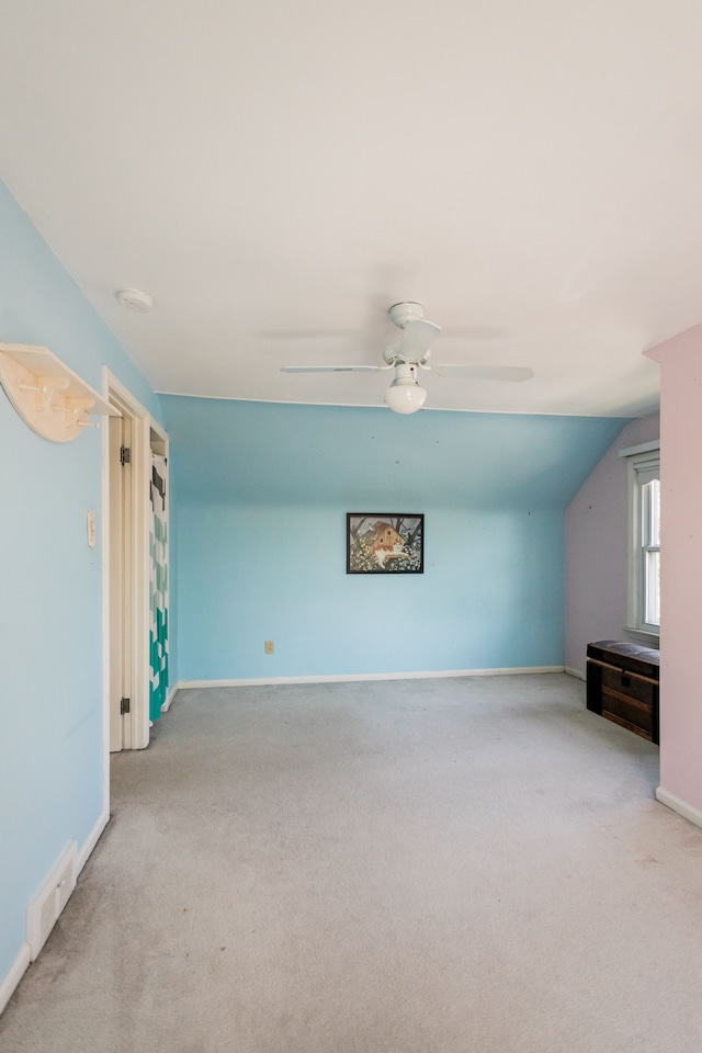unfurnished living room featuring carpet flooring, baseboards, ceiling fan, and lofted ceiling