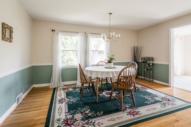 dining area with wood finished floors, a chandelier, and baseboards
