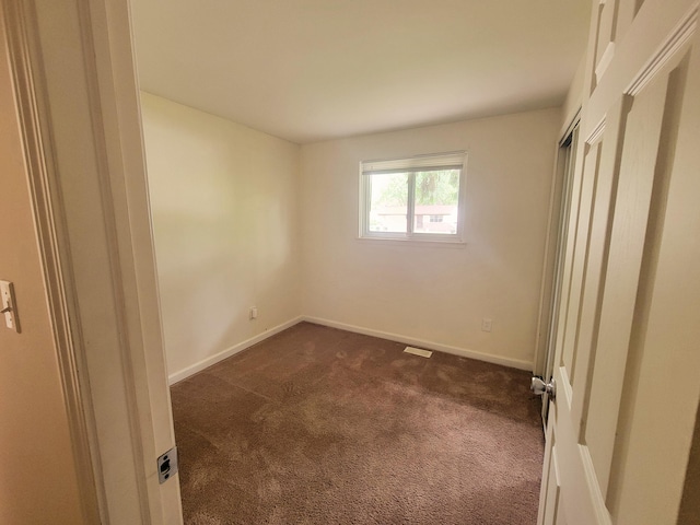 16442 Brandt St, Romulus, MI 48174 - unfurnished bedroom with dark carpet and baseboards