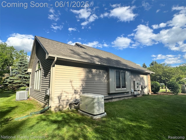 3052 Rivers Edge Dr, Wayne, MI 48184 - view of side of home with a lawn, central AC unit, and roof with shingles