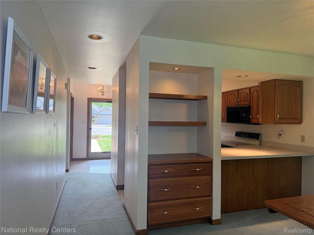 3052 Rivers Edge Dr, Wayne, MI 48184 - kitchen with stove, black microwave, light carpet, a chandelier, and brown cabinetry