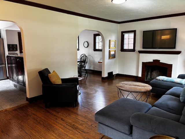 404 Pauline Blvd, Ann Arbor, MI 48103 - living area with arched walkways, crown molding, dark wood-style flooring, baseboards, and a textured ceiling