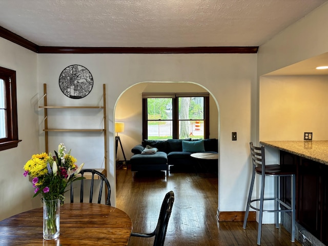 404 Pauline Blvd, Ann Arbor, MI 48103 - dining area with ornamental molding, dark wood-style floors, arched walkways, a textured ceiling, and baseboards