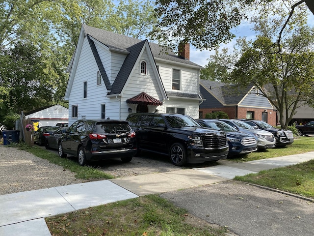 404 Pauline Blvd, Ann Arbor, MI 48103 - view of side of home featuring a chimney, a shingled roof, and uncovered parking
