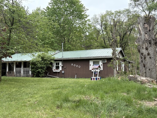 8000 Derry Rd, Vestaburg, MI 48891 - view of side of home featuring metal roof, a yard, and a porch