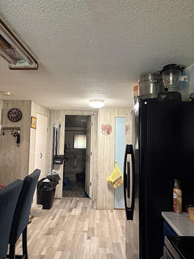 8000 Derry Rd, Vestaburg, MI 48891 - kitchen featuring a textured ceiling, light wood finished floors, and wood walls