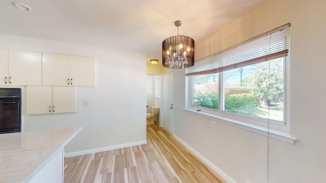 26817 Newport Ave, Warren, MI 48089 - unfurnished dining area with light wood-style floors, a chandelier, and baseboards