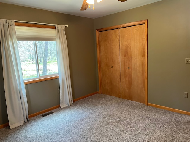 11055 Kopko Trl, Roscommon, MI 48653 - unfurnished bedroom featuring carpet flooring, a closet, baseboards, and a ceiling fan