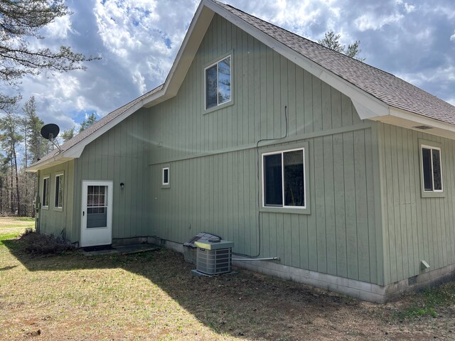 11055 Kopko Trl, Roscommon, MI 48653 - back of property with roof with shingles, a lawn, and cooling unit