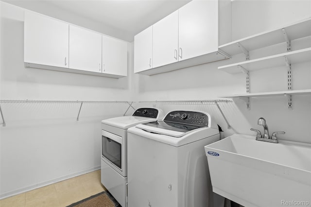 3819 Hazelett Dr, Waterford, MI 48328 - washroom with independent washer and dryer, cabinet space, and light tile patterned floors
