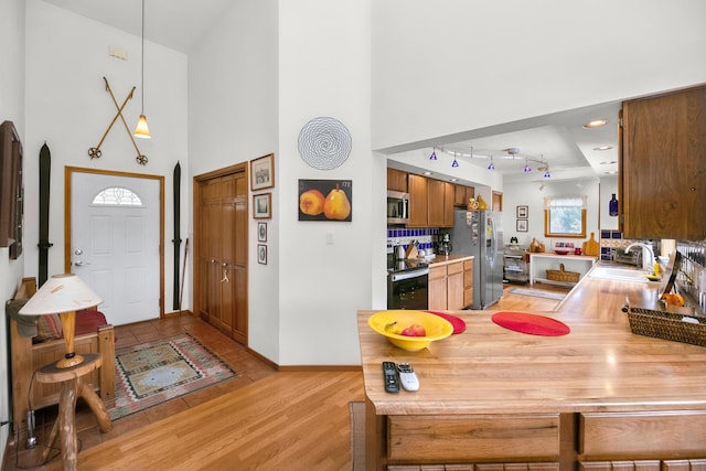 838 Able Rd, Buchanan, MI 49107 - dining space featuring a towering ceiling, arched walkways, light wood-style floors, baseboards, and recessed lighting