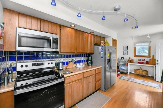 838 Able Rd, Buchanan, MI 49107 - kitchen with appliances with stainless steel finishes, light countertops, light wood finished floors, and decorative backsplash