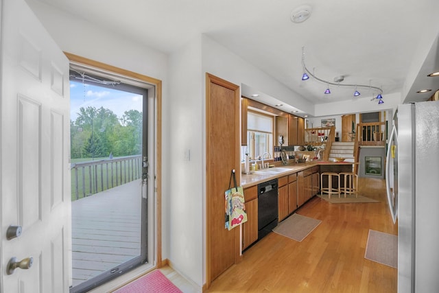 838 Able Rd, Buchanan, MI 49107 - kitchen with freestanding refrigerator, dishwasher, a sink, light wood-type flooring, and brown cabinetry