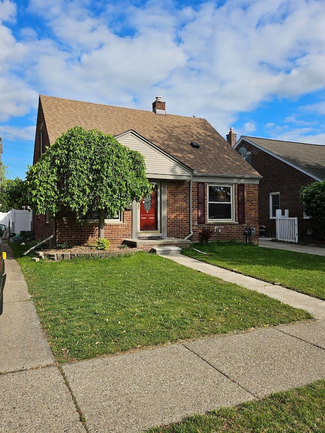 2043 Edgewood St, Dearborn, MI 48124 - view of front of home featuring a front lawn, brick siding, a shingled roof, and a chimney