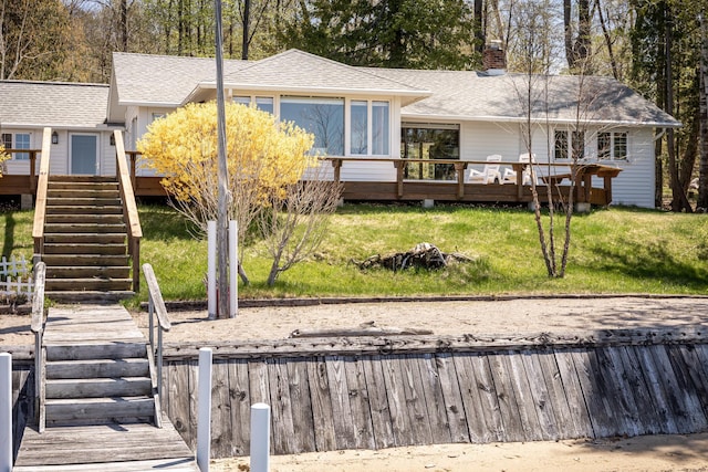 8432 S Dunns Farm Rd, Maple City, MI 49664 - rear view of house featuring stairs, a wooden deck, roof with shingles, a lawn, and a chimney