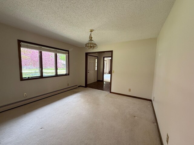 6035 W Trails End Rd, Ludington, MI 49431 - unfurnished room with a baseboard heating unit, light carpet, a textured ceiling, and baseboards