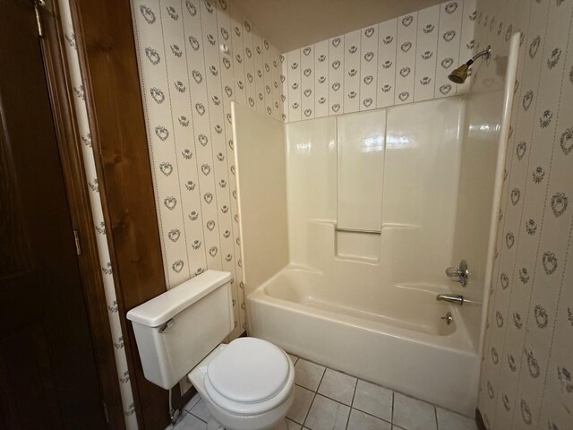6035 W Trails End Rd, Ludington, MI 49431 - bathroom with tile patterned floors, toilet, tub / shower combination, and wallpapered walls