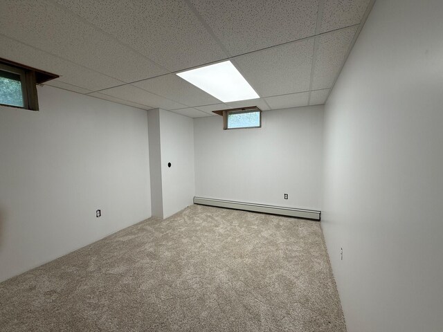 6035 W Trails End Rd, Ludington, MI 49431 - basement featuring baseboard heating, carpet flooring, and a drop ceiling