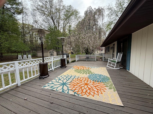 6035 W Trails End Rd, Ludington, MI 49431 - deck with a storage unit, an outbuilding, and view of scattered trees