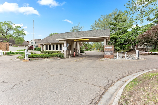 view of front of home featuring a shingled roof, driveway, and a carport