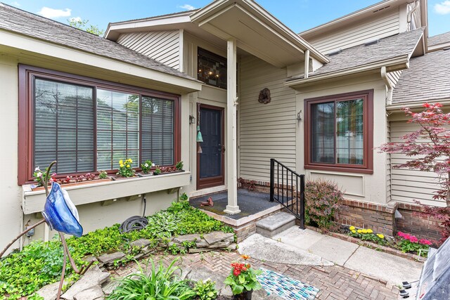 property entrance featuring a shingled roof