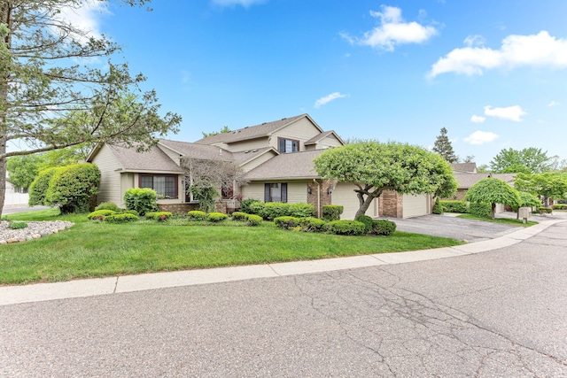 view of front facade featuring a front yard, brick siding, driveway, and a shingled roof