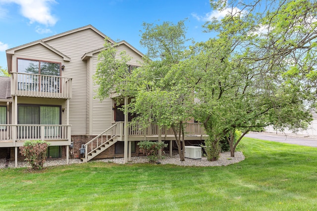 back of property with a lawn, a deck, and stairway