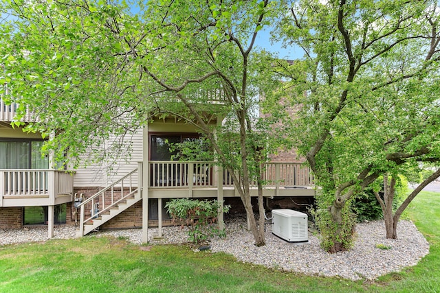 back of property featuring stairs, a lawn, and a deck